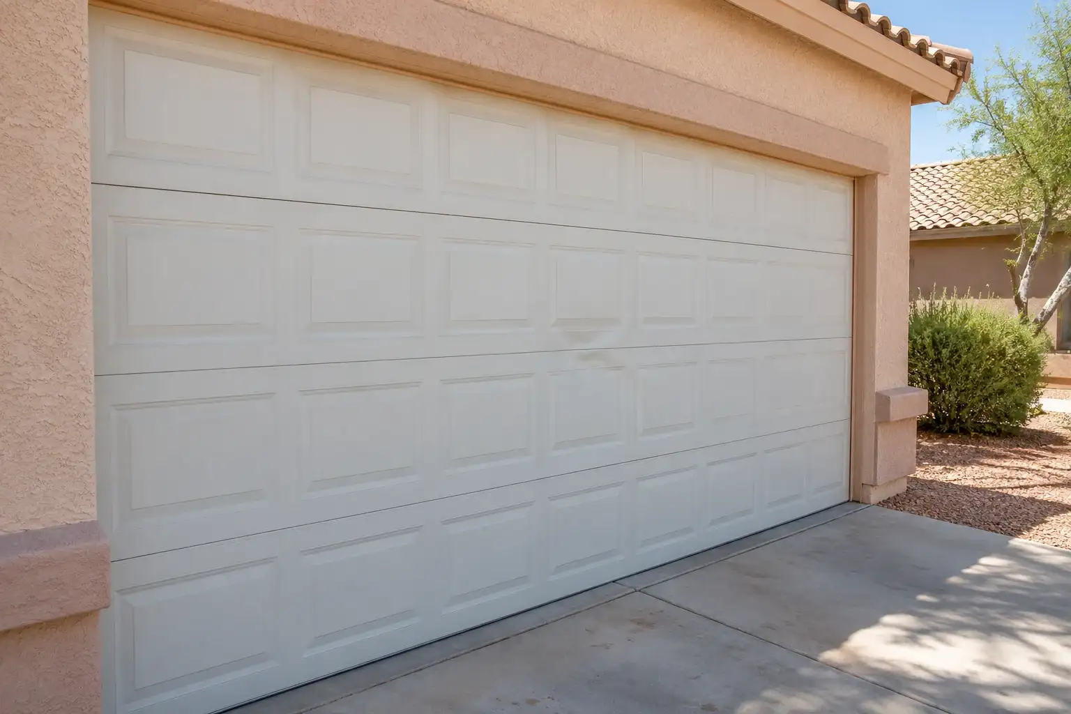 White garage door with a shallow dent in one middle panel