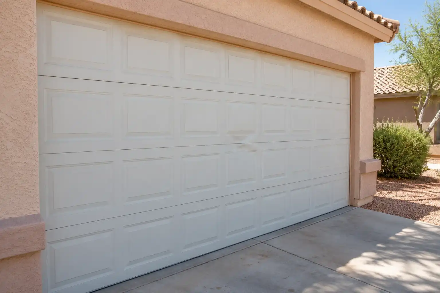White garage door with a shallow dent in one middle panel